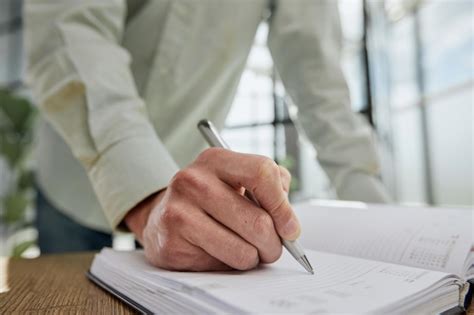 Premium Photo Businessman Writes With A Pen In Diary Sunny Office