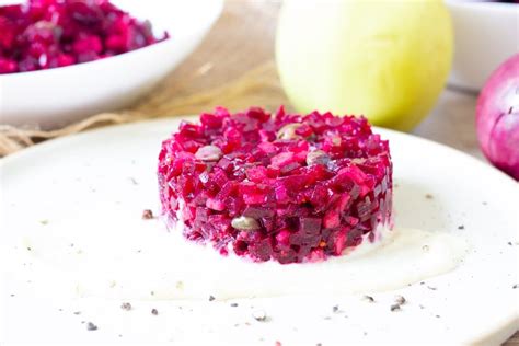 A White Plate Topped With Beet Cake Next To Bowls Of Fruit