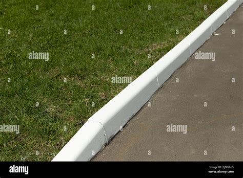 White curb on road. Landscaping in park. Painted curb Stock Photo - Alamy