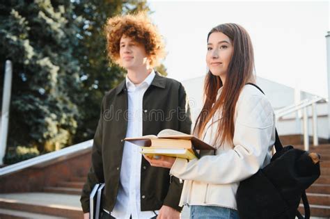 Front View of Two Students Walking and Talking in an University Campus. Stock Image - Image of ...