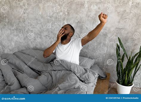 Sleepy Young Black Guy Yawning Stretching After Wake Up Stock Photo