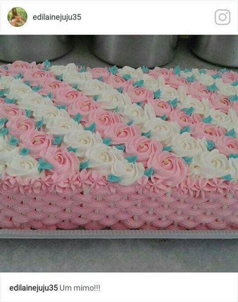 A Cake With Pink And White Frosting Roses On It S Side Sitting On A Table