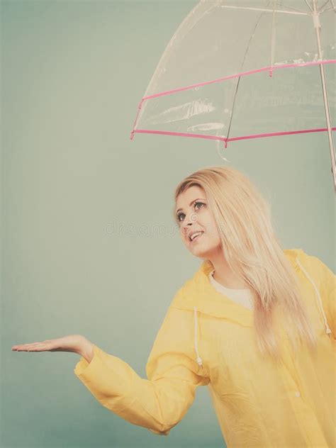 Woman Wearing Raincoat Holding Umbrella Checking Weather Stock Image