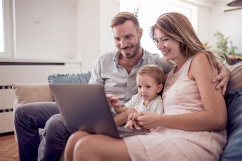 Familia caucásica feliz con portátil en el sofá Foto Premium