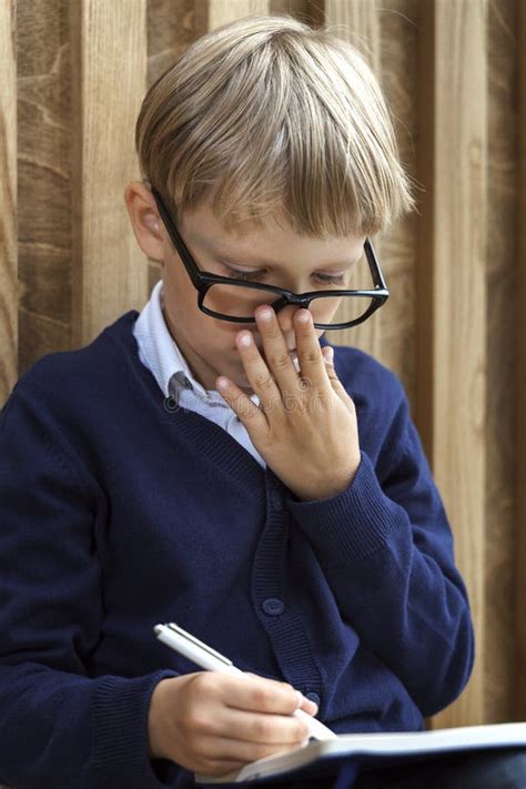 Un Ni O Peque O Con Gafas Escribe Con Un Bol Grafo En Un Cuaderno Foto