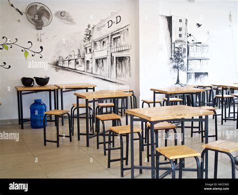 Cafe wall art timbre wooden tables chairs stools Stock Photo - Alamy