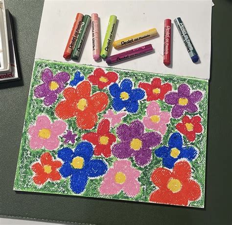 Some Crayons Are Laying On Top Of A Paper With Flowers And Daisies