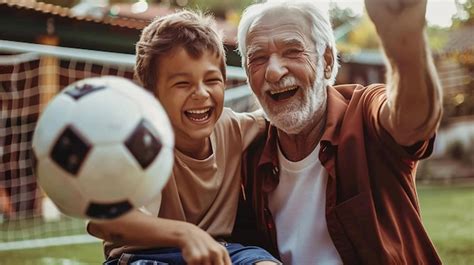 Premium Photo Joyful Grandfather And Grandson Playing Football Together