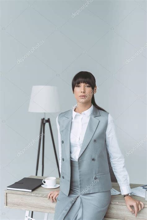 Attractive Businesswoman Leaning Table Looking Camera Isolated Gray