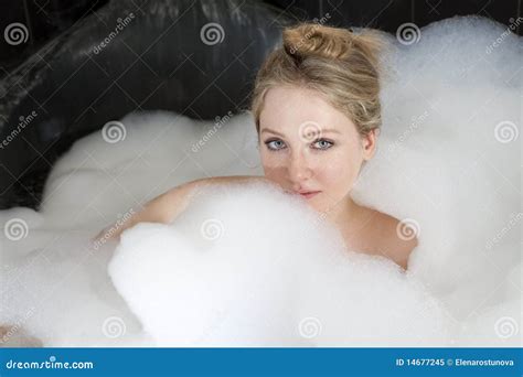 La Femme Sérieuse Apprécie La Bain mousse Dans La Baignoire Image