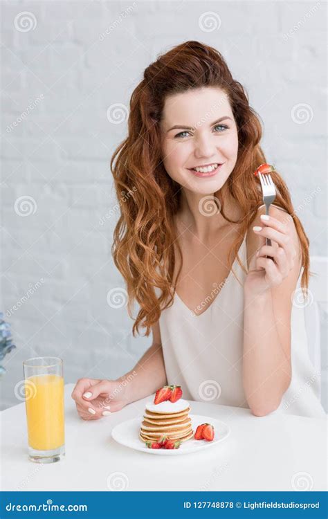 Beautiful Young Woman Eating Pancakes With Strawberry And Orange Juice