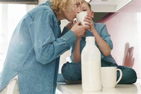 Mother And Her Cute Son Drinking Milk On The Kitchen Stock