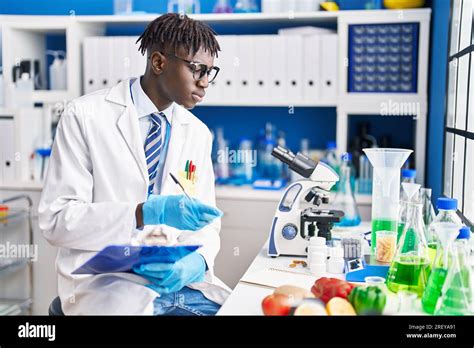 African American Man Scientist Writing Report At Laboratory Stock Photo