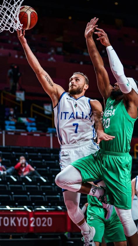 Two Men Playing Basketball Against Each Other On A Court