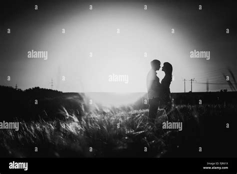 Black white photography romantic silhouette couple standing and kissing ...