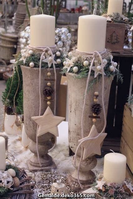 Three White Candles Sitting On Top Of A Table Next To Christmas