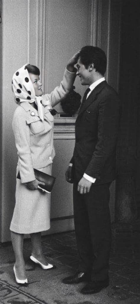 A Man And Woman Standing Next To Each Other In Front Of A Door With