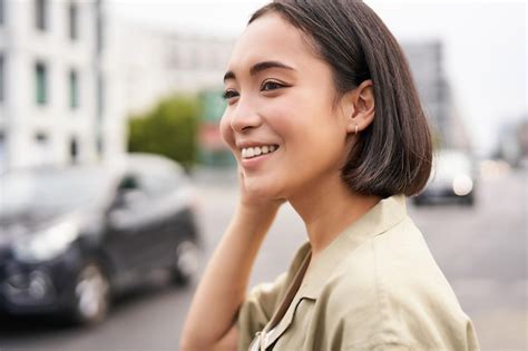 아름 다운 젊은 여자 아시아 여자의 초상화를 닫습니다 행복 미소 거리에 야외 서 무료 사진