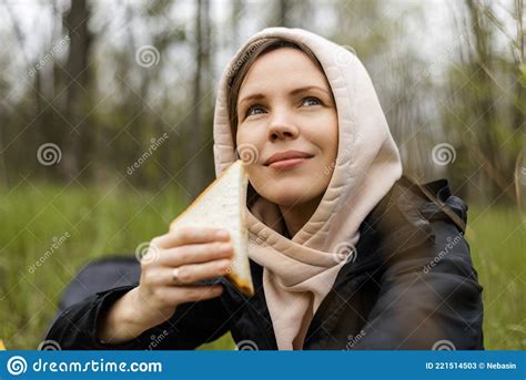 An Adult Attractive Woman Eats A Sandwich Outdoors In The Forest Park