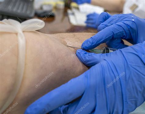 manos con guantes azules de un profesional médico insertar una aguja en