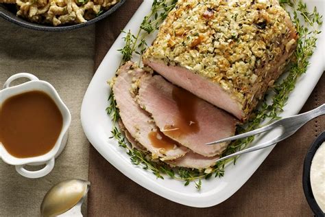 a plate topped with meat covered in gravy next to two bowls of food