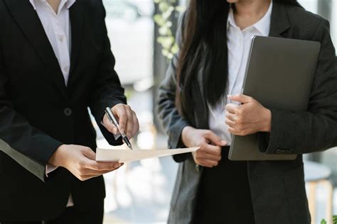 Two Businessmen Deep In Discussion Together While Standing In An Office