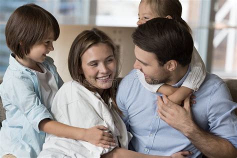 Alegres Lindos Niños Pequeños Abrazando a Mamá Y Papá Positivos Foto de