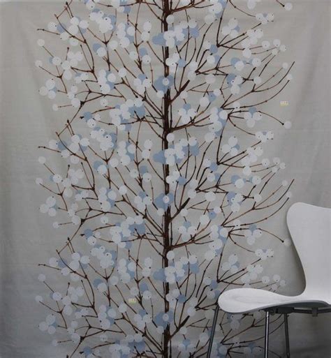 A White Chair Sitting In Front Of A Wall With Flowers On It