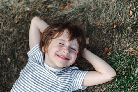 Photo Libre De Droit De Enfant Allongé Sur Le Dos Dans Lherbe Du Parc