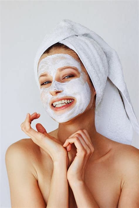 Beautiful Young Woman Applying Facial Mask On Her Face Skin Care And