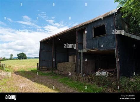 Rusty Old Farm Barn Made Of Corrugated Metal Storing Hay Bales Inside