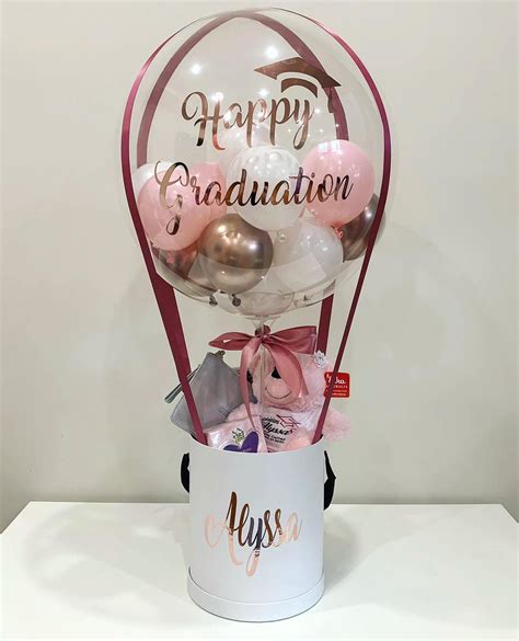 A Balloon Filled With Pink And Gold Balloons In A White Bucket That