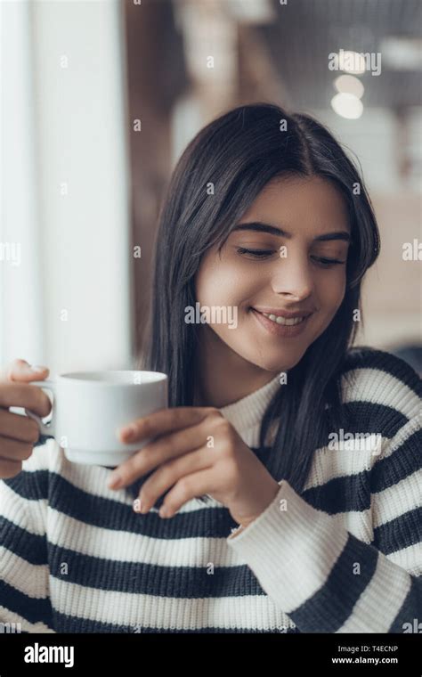 Beautiful Caucasian Girl In Casual Clothes Smiling While Sitting In