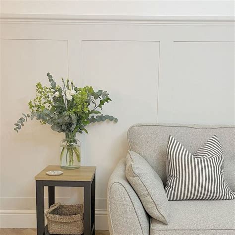 A Living Room With A Couch Table And Vase On The Floor Next To It