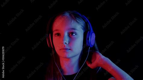 Beautiful Teenager Girl Listening Music Headphones In Dark Room With