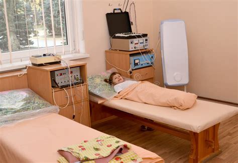 A Menina Doente Pequena Senta Se Em Uma Cama E Bebe Se A Gua De Um