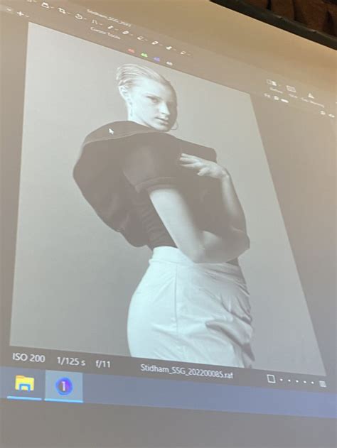 A Woman Is Standing In Front Of A Projector Screen With Her Hands On