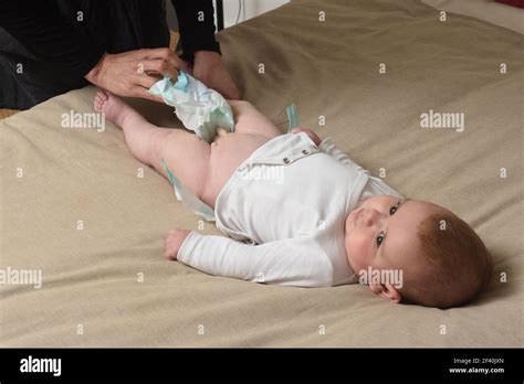 changer la couche sur le bébé qui est couché lit Photo Stock Alamy