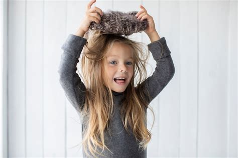 Adorable Fille Blonde Jouant Avec Un Chapeau D Hiver Photo Gratuite