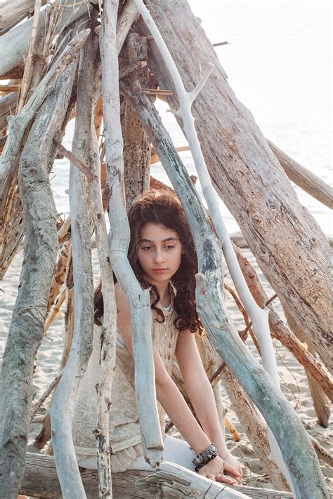 Daydreaming Girl Sitting On A Trunk On The Beach At Sunset Del