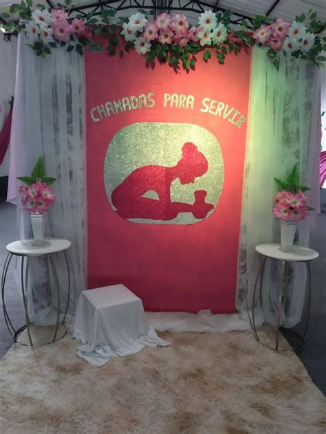 The Backdrop Is Decorated With Pink Flowers And Green Leaves While