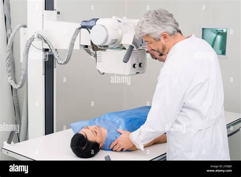 Male Doctor Adjusting X-ray Machine Over Patient In Hospital Stock ...