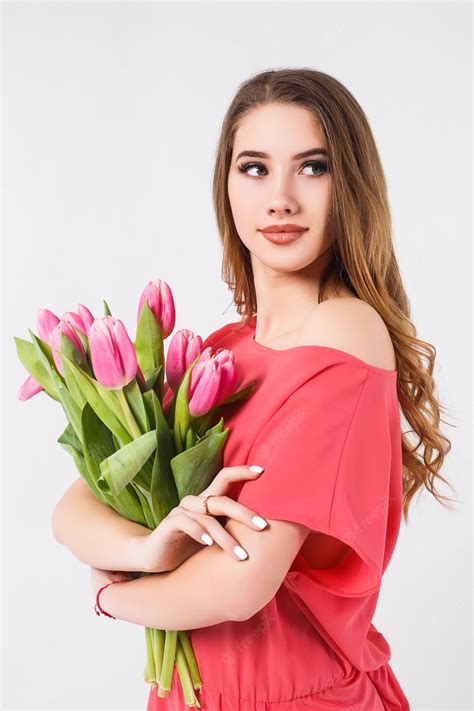 Premium Photo A Beautiful Young Woman Stands On A White Wall Wearing