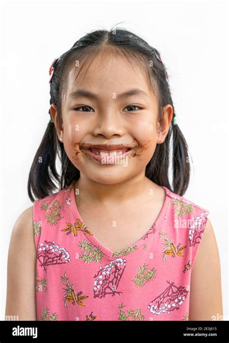 Portrait Asian cute child girl with messy of chocolate around her mouth ...