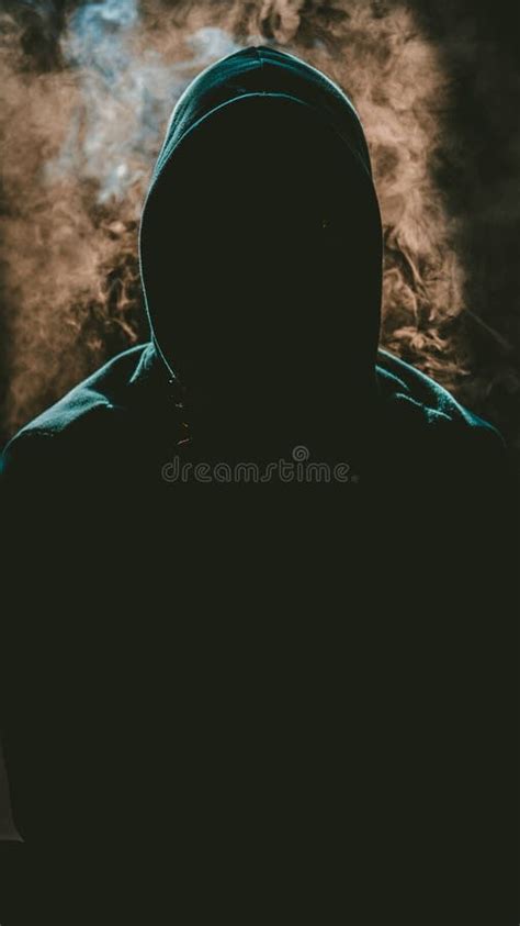 Mysterious Person Wearing a Hoodie with a Darkened Face and the Smoke ...