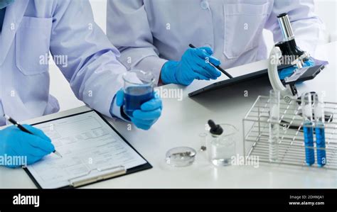 Attractive Young Scientist Team In Lab Coat And Safety Goggles Working