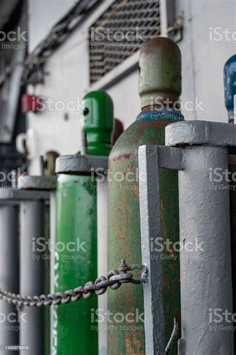 Compressed Gas Cylinders Being Stored Vertically Secured By A Metal