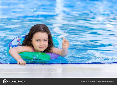 Une Petite Fille Nage Dans Piscine Avec Anneau Gonflable Montrant Image