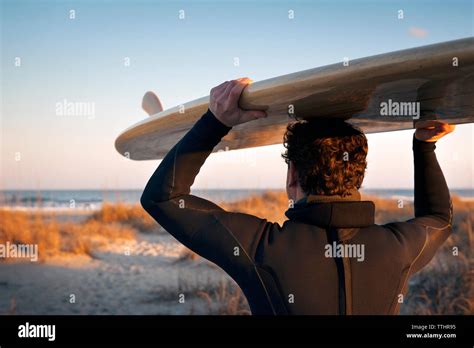 Close Up Of Surfer Carrying Surfboard On Head At Beach Stock Photo Alamy