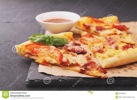 Pizza With Sausage Ham Tomato And Cheese Decorated With Basil And